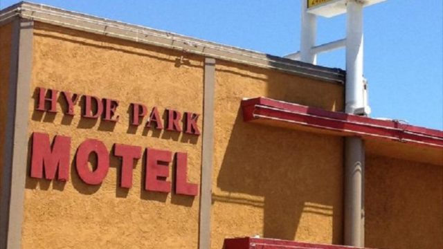 the exterior of a yellow building with red letters that reads Hyde Park Motel