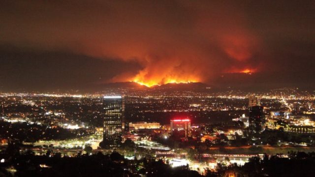 a fire burns at night on a wooded hill overlooking the city of Burbank, California