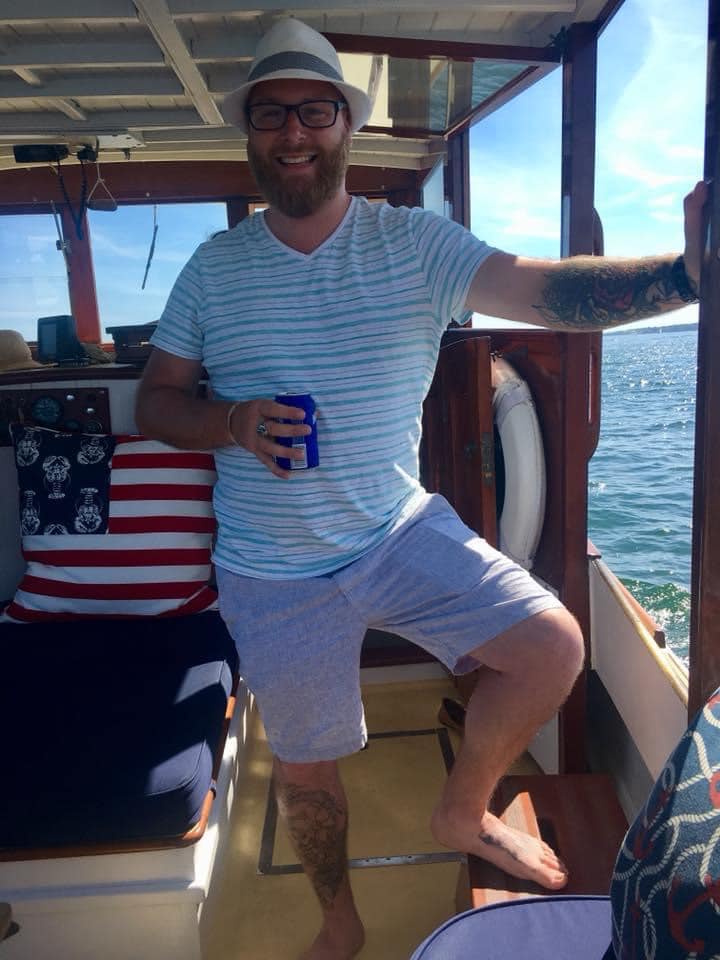 Richard Solitro Jr. holding a drink and smiling on a boat.