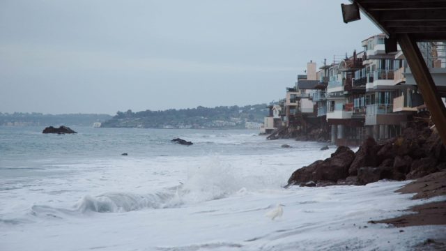 water sweeping across beachfront homes in malibu