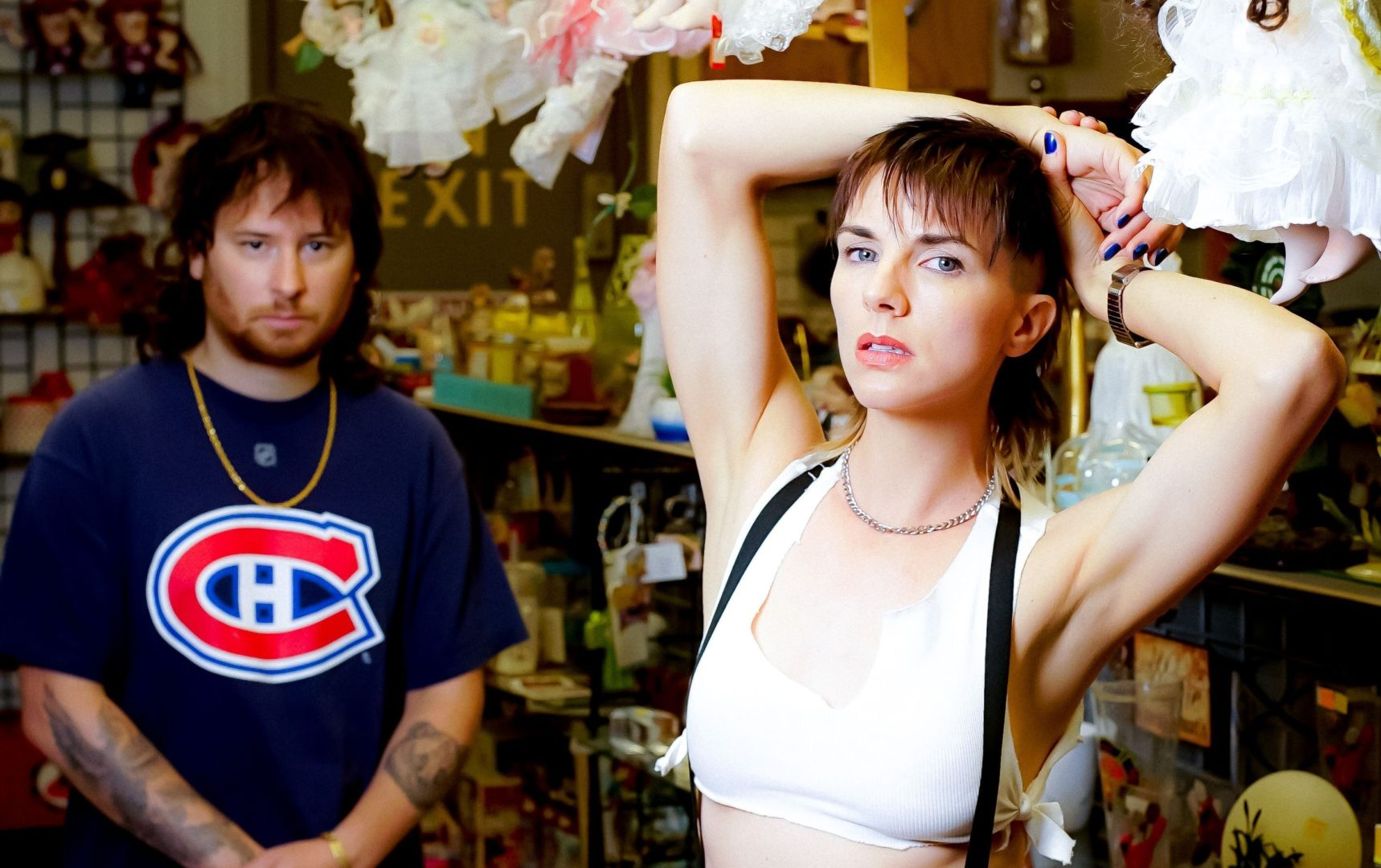 a portrait of the members of the band broken baby, showing a person wearing a white tank top in the foreground and a person wearing a cubs jersey in the background