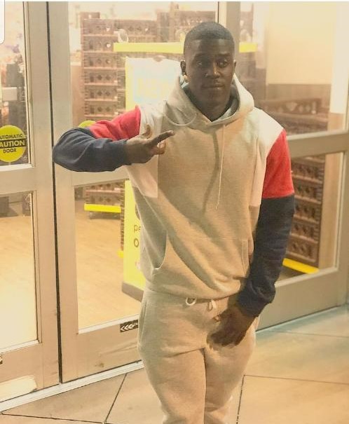 jamaal simpson wearing a hoodie and posing in front of a store