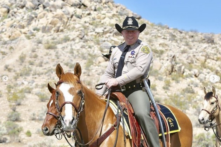 lasd sheriff alex villanueva wearing a black cowboy hat and riding a horse
