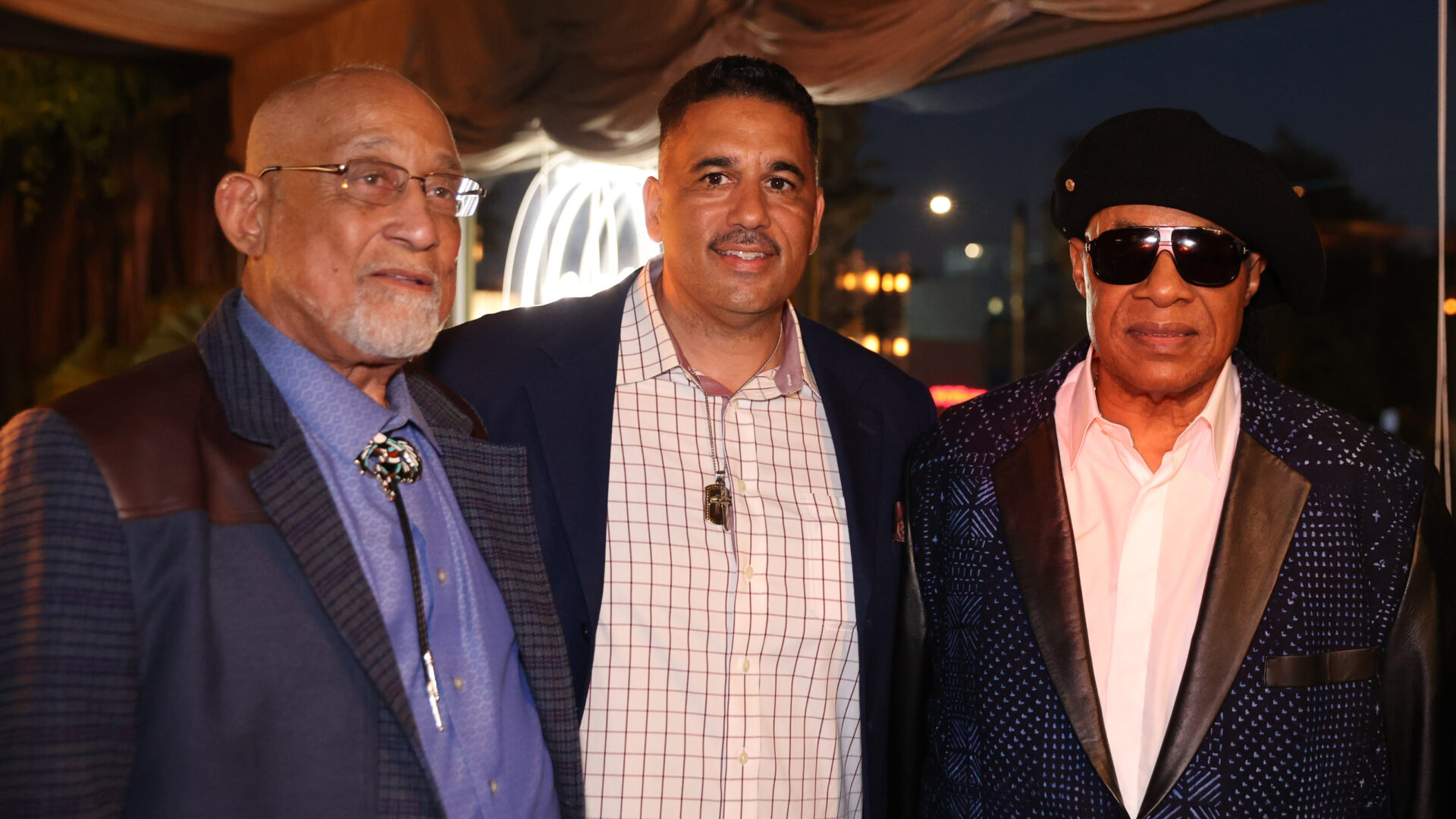 Former Lancaster Mayor Bishop Henry Hearns, Lieutenant Eric Strong, and Stevie Wonder stand shoulder to shoulder at La Conde Restaurant in Santa Monica.
