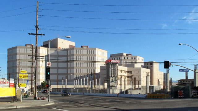 The Los Angeles Men's Central Jail with signs advertising cash bail across the street from it.