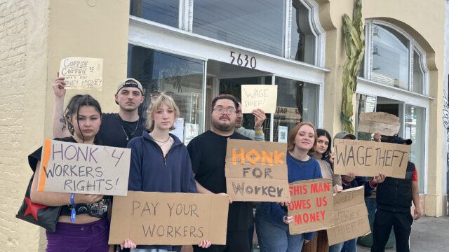 A group of protestors stands outside of Coffee Coffee restaurant; their signs read "Honk 4 Workers' Rights" and "This man owes us money."