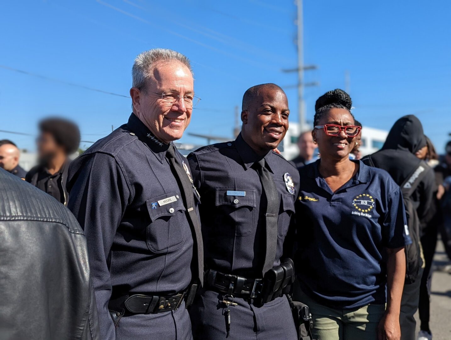 Daphne Bradford of Build Blue Bridges stnads for a photo with LAPD Chief Moore and another LAPD Officer.