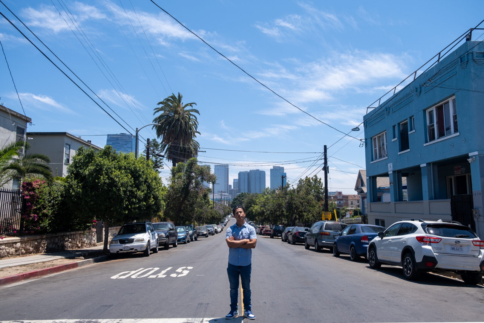 Standing in the center of the Pico Union community where Kent grew up for the majority of his life. Downtown Los Angeles is seen in the background. July 2023. Credit: Rodrigo Magaña | Knock LA