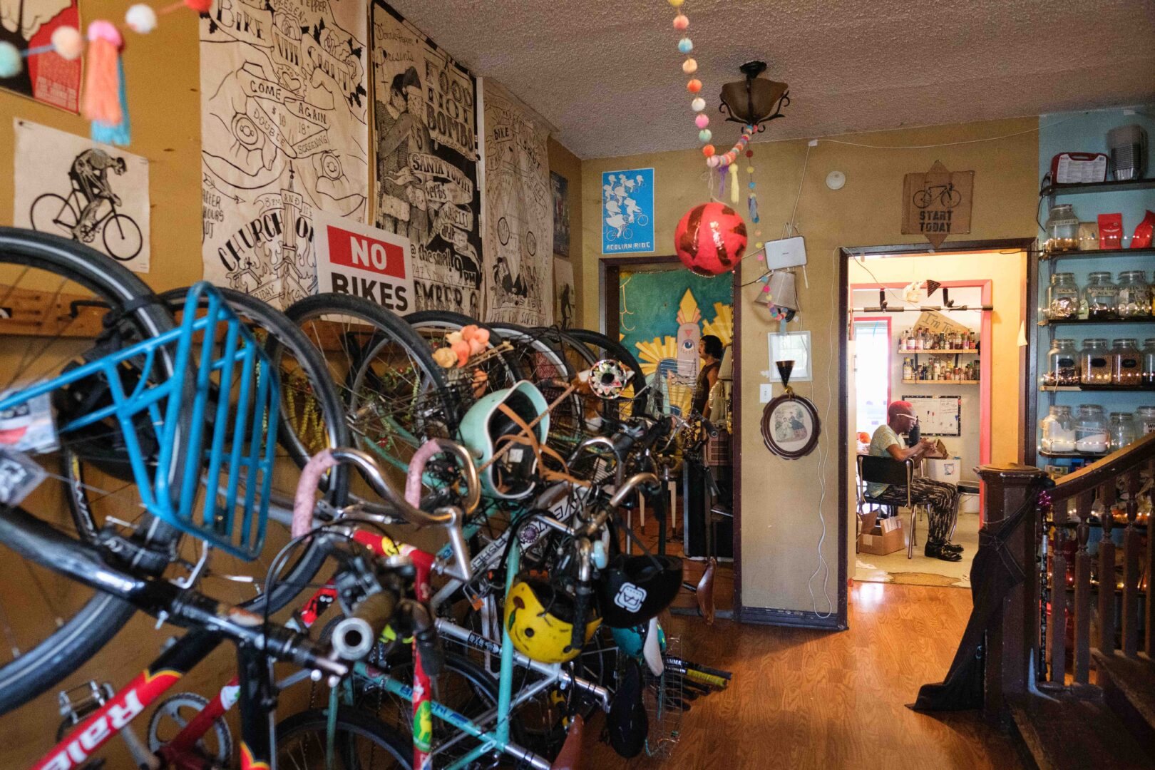 The main hallway of AgLago as seen from the front door. Residents store their bikes on a bike rack here. Residents Jeremy and Revé are shown in the background. July 2023.